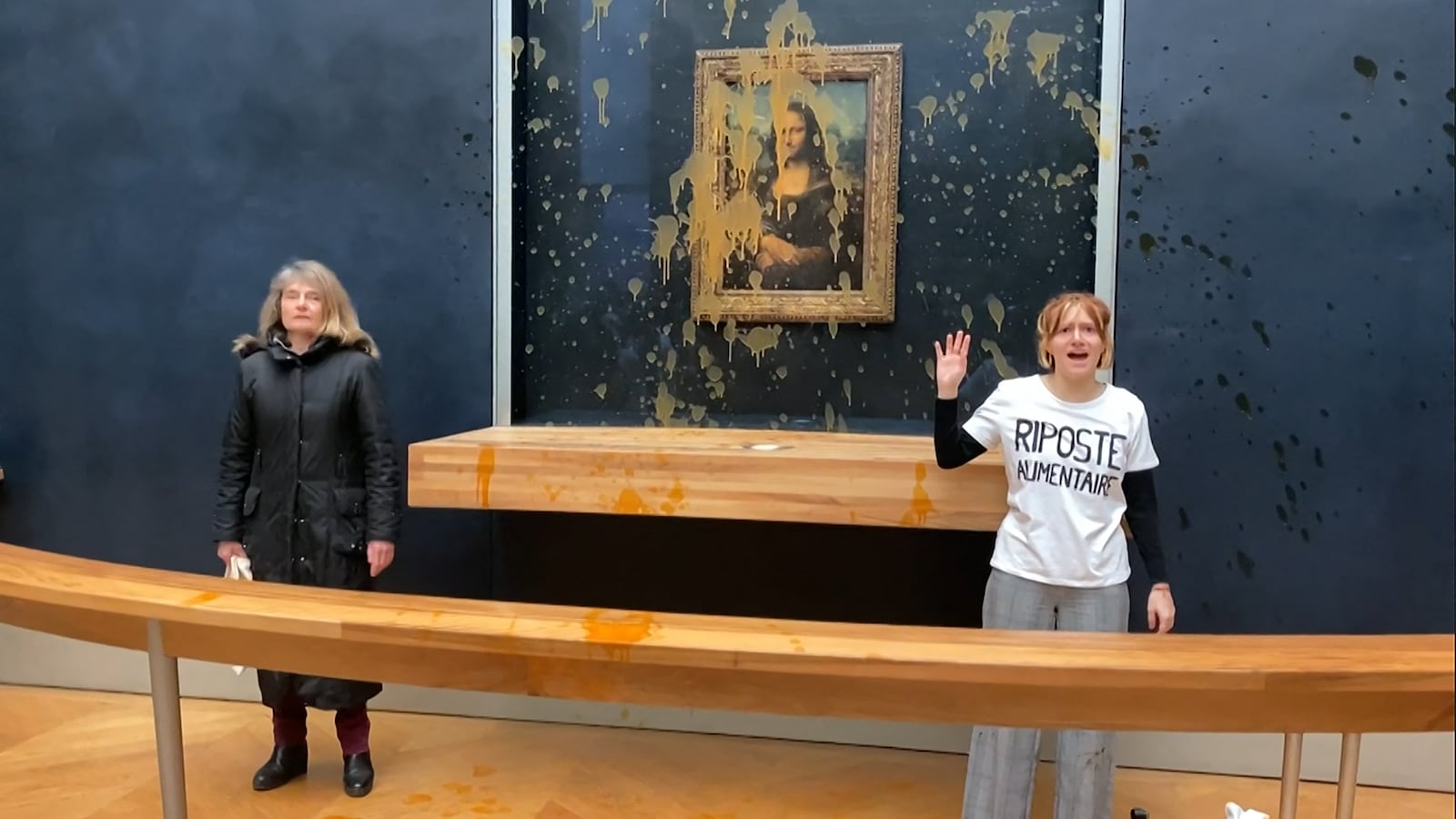 Protestors stand alongside the Mona Lisa.