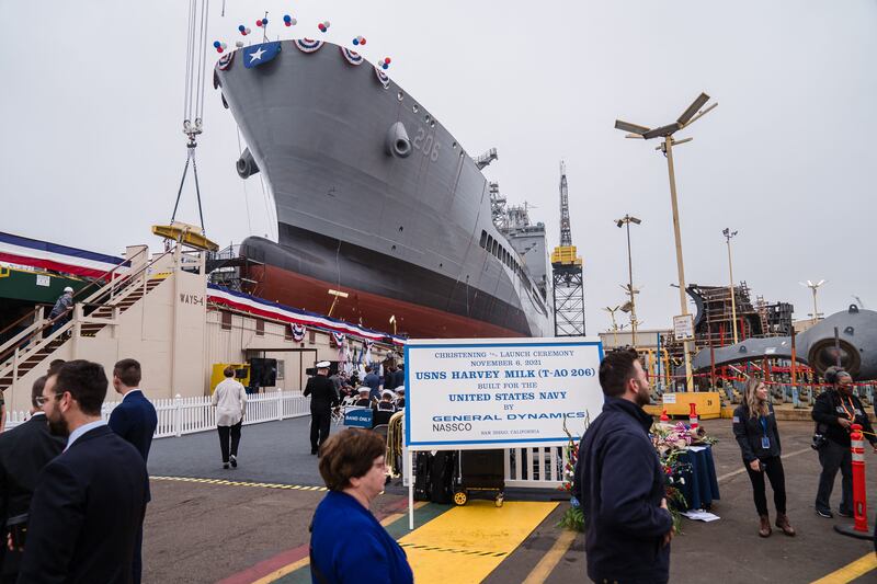 Guests walk past the USNS Harvey Milk at General Dynamics NASSCO shipyard during the ceremonial address in San Diego, California on November 6, 2021. - One of the first openly gay politicians in the United States, who was assassinated four decades ago, will have a ship named after him this weekend, as the US military looks to keep step with modern-day social attitudes. The USNS Harvey Milk honours a former navy diver who served at a time there was a ban on homosexuality in the armed forces, and who was later shot dead in San Francisco, months after winning public office. (Photo by ARIANA DREHSLER / AFP) (Photo by ARIANA DREHSLER/AFP via Getty Images)