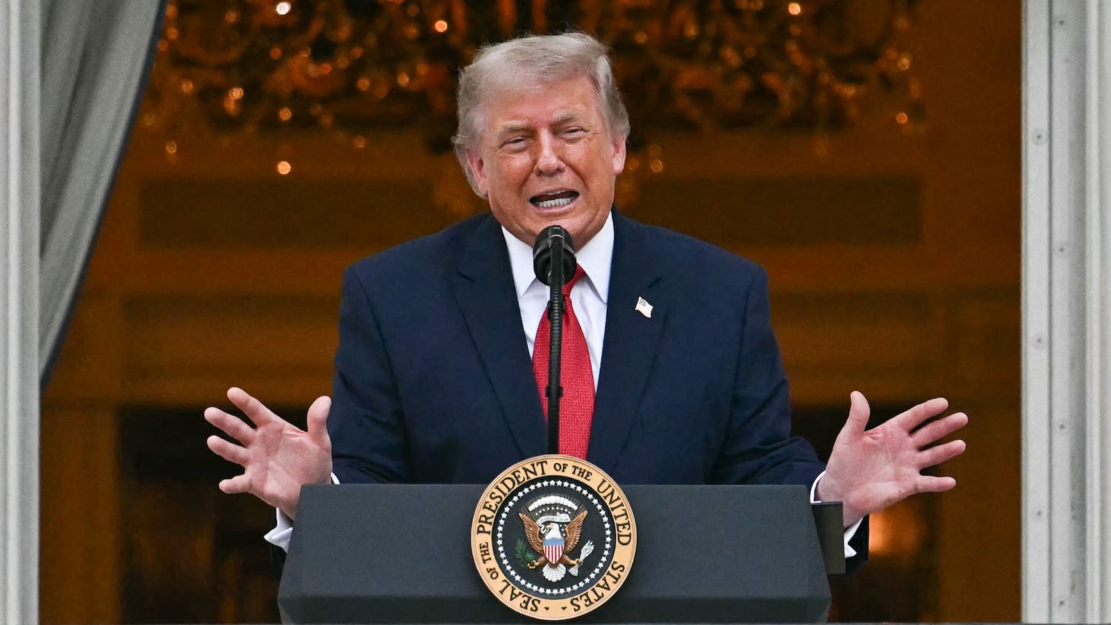 US First Lady Melania Trump looks on as US President Donald Trump speaks at the Congressional Picnic from the White House balcony in Washington, DC on May 19, 2026.