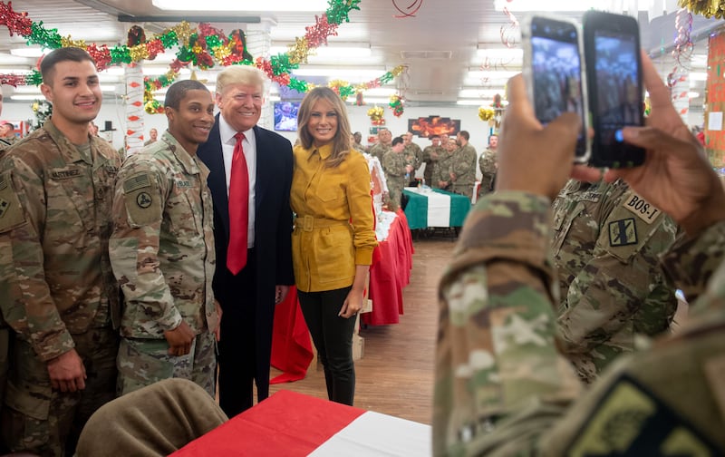 US President Donald Trump and First Lady Melania Trump take photos with members of the US military during an unannounced trip to Al Asad Air Base in Iraq on December 26, 2018. - President Donald Trump arrived in Iraq on his first visit to US troops deployed in a war zone since his election two years ago (Photo by SAUL LOEB / AFP) (Photo credit should read SAUL LOEB/AFP via Getty Images)