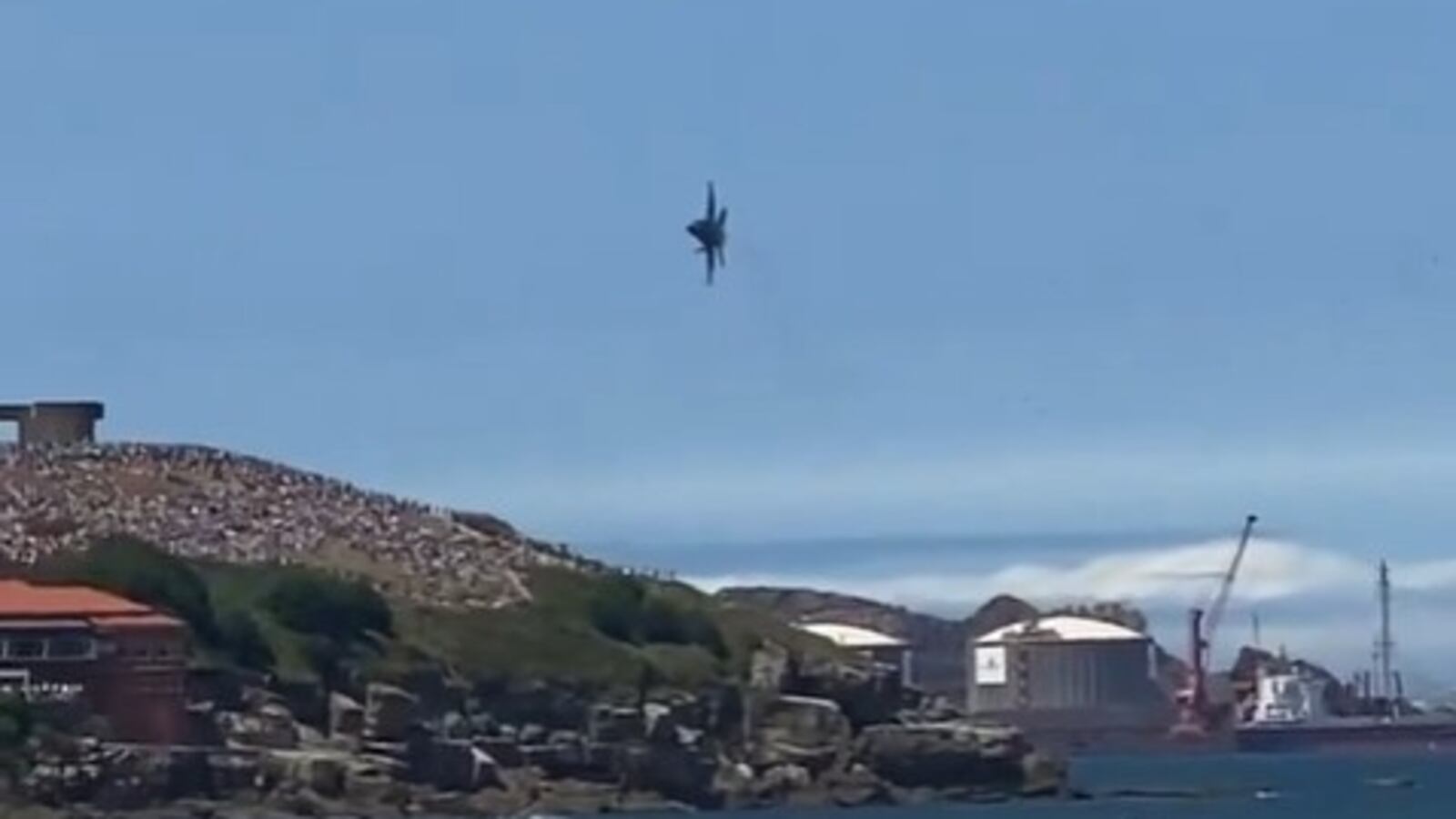 A fighter jet performs an low pass over San Lorenzo Beach during a Spanish air show.