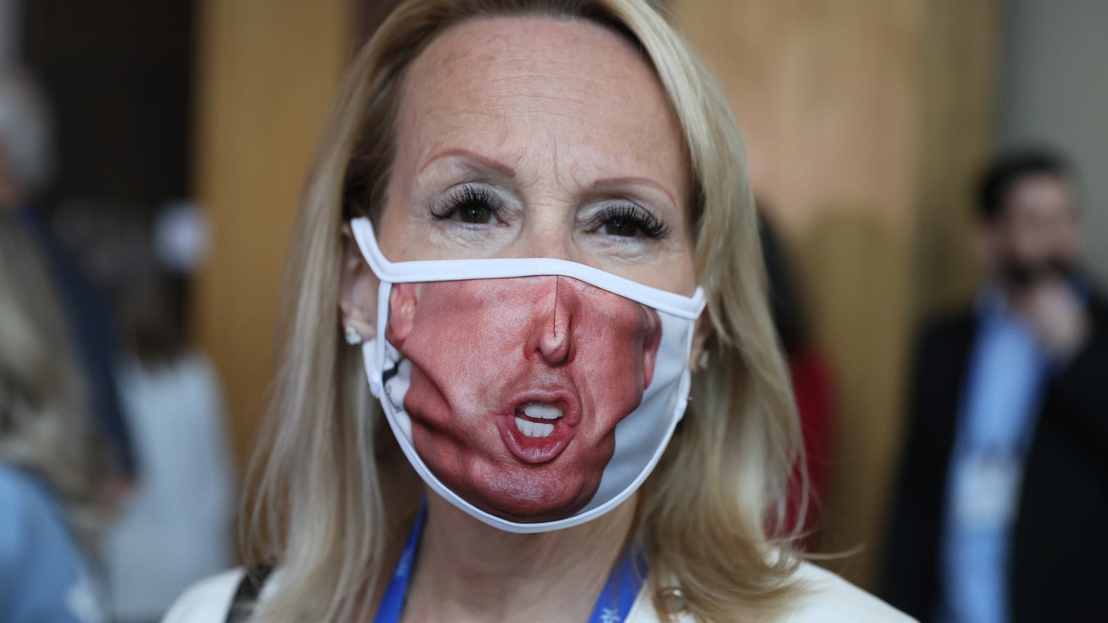 A woman wears a face mask with a picture of President Donald Trump