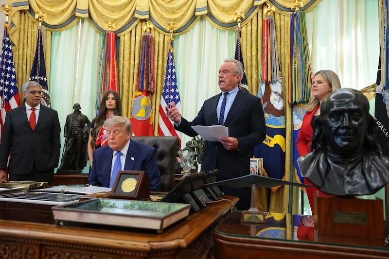 Health and Human Services Secretary Robert F. Kennedy Jr. (2nd-R), accompanied by (L-R) National Institutes of Health Director Jay Bhattacharya, Jayme Leagh Franklin with the The Conservateur, U.S. President Donald Trump, and Deputy Assistant to the President for Domestic Policy Dr. Heidi Overton (R), speaks before Trump signs an executive order calling for childhood vaccine shots to be spaced out into separate visits during an event in the Oval Office of the White House on Aug. 10, 2026 in Washington, DC.