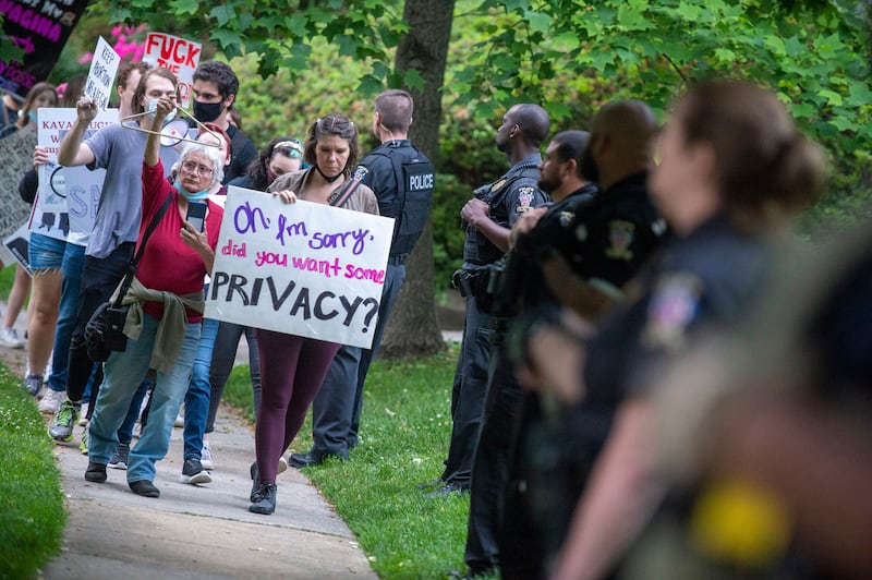 Abortion-rights advocates demonstrate as police officers look on outside the home of U.S. Supreme Court Chief Justice John Roberts on May 18, 2022 in Chevy Chase, Maryland. Protests have been organized intermittently outside the homes of justices who signed onto - though Roberts did not sign - a draft opinion that would overturn the landmark decision Roe v Wade, which made abortion legal across the U.S. in 1973.