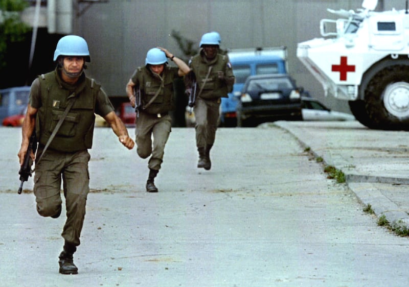 French UN soldiers being evacuated under fire run from Sarajevo's Radio and Television building July 27, 1993 after it came under attack by at least 3 artillery shells.  REUTERS/Chris Helgren