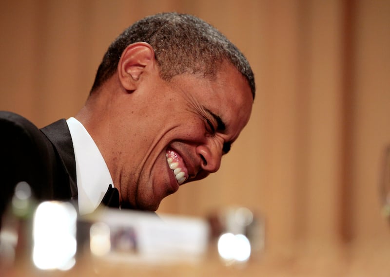 Barack Obama laughs at a joke.