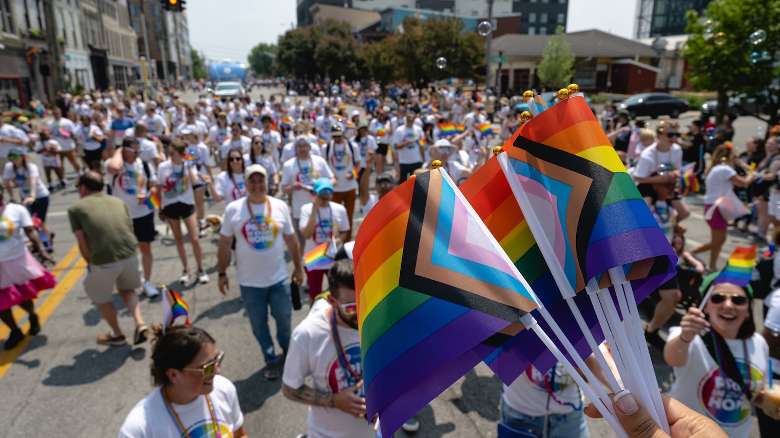 Parade participants holding Pride flags are seen during the Kentuckiana Pride Parade.