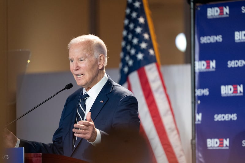 Former President Joe Biden speaks at a podium in front of the U.S. flag