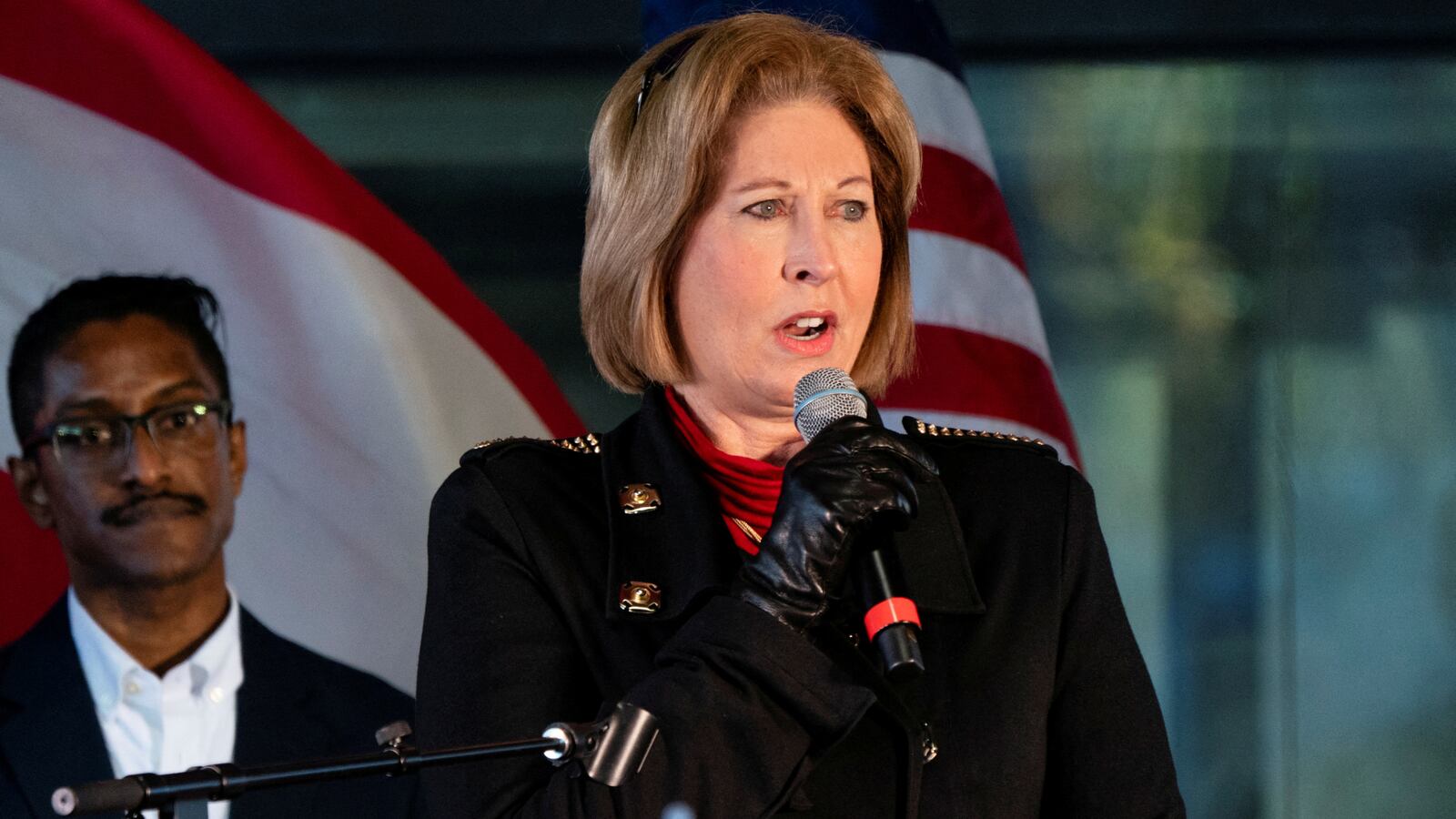 Sidney Powell holds a microphone while she speaks at a press conference in Georgia.