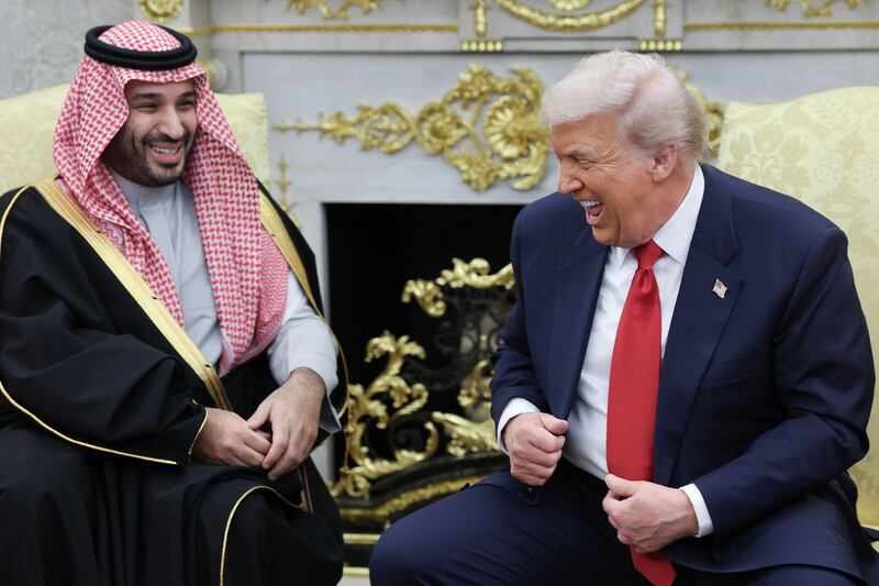 U.S. President Donald Trump (R) jokes with Crown Prince and Prime Minister Mohammed bin Salman of Saudi Arabia during a bilateral meeting in the Oval Office of the White House on November 18, 2025 in Washington, DC.