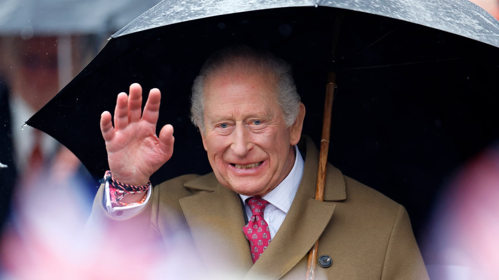 King Charles III shelters under an umbrella as he meets members of the public during a walkabout after visiting The Sun Inn on February 5, 2026 in Dedham, Essex.