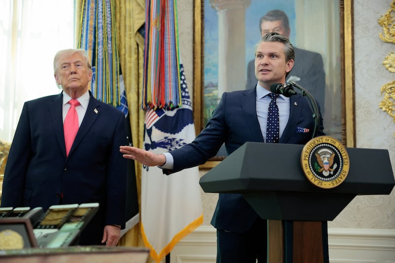 U.S. President Donald Trump stands next to U.S. Defense Secretary Pete Hegseth as he speaks, following Markwayne Mullin's swearing-in as Department of Homeland Security (DHS) Secretary, at the White House in Washington, D.C.
