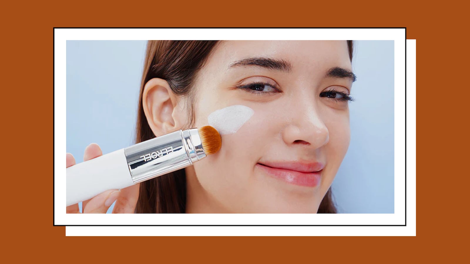 Model applying ELROEL Blanc Cover Cream Stick V to her cheek using the built-in blending brush for smooth, even tone-up coverage.