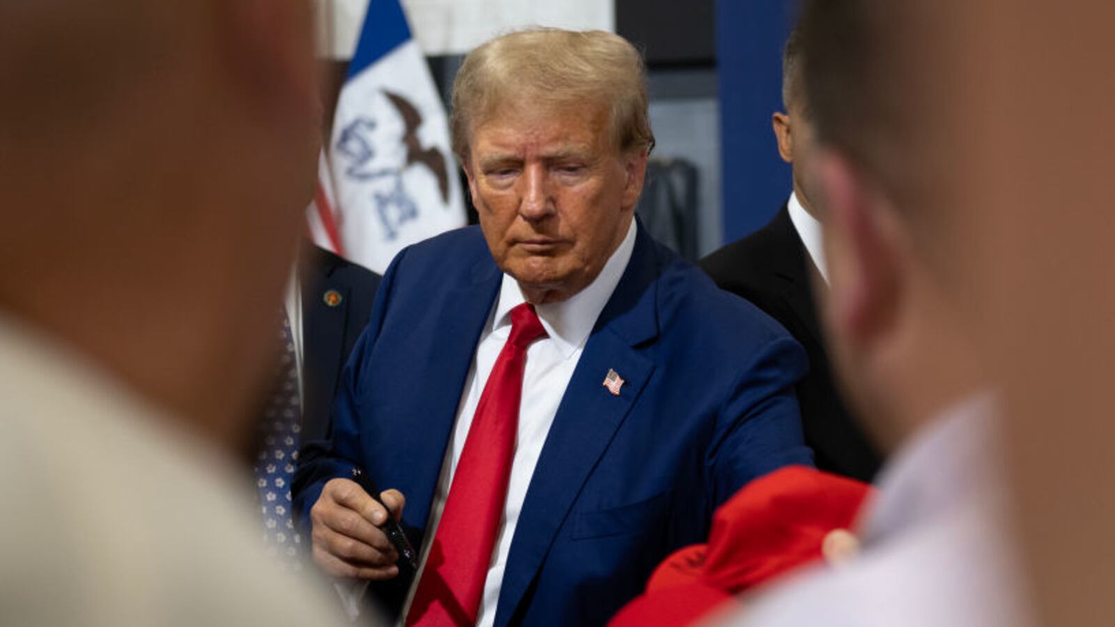 Former President Donald Trump signs items for a crowd of supporters.