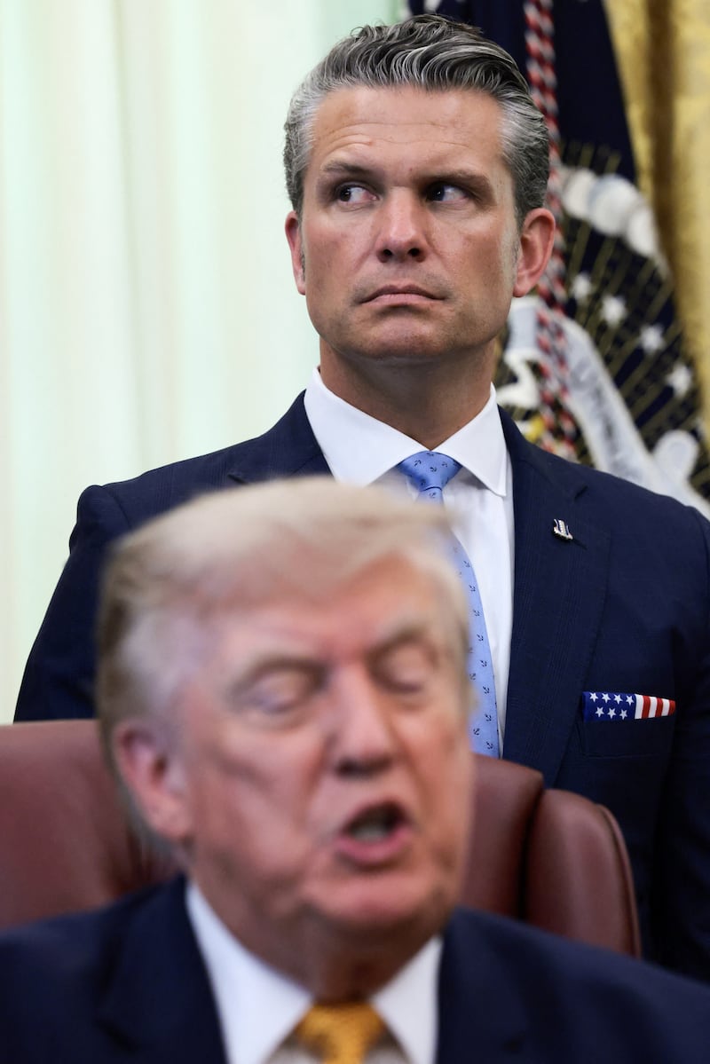 U.S. Secretary of Defense Pete Hegseth listens as U.S. President Donald Trump answers questions from the media after signing an executive order establishing the President's Military Spouse Commission to be chaired by Jennifer Rauchet, wife of Hegseth, in the Oval Office at the White House in Washington, D.C., U.S., August 3, 2026. REUTERS/Evelyn Hockstein