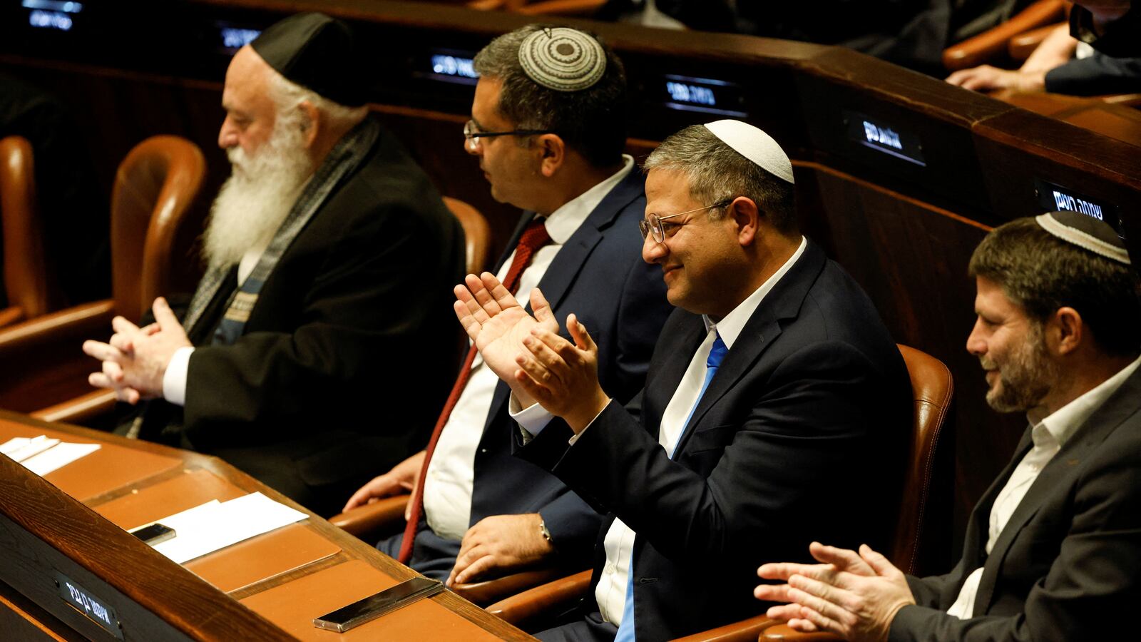 Itamar Ben-Gvir and Bezalel Smotrich sit and clap at a special session at the Knesset.