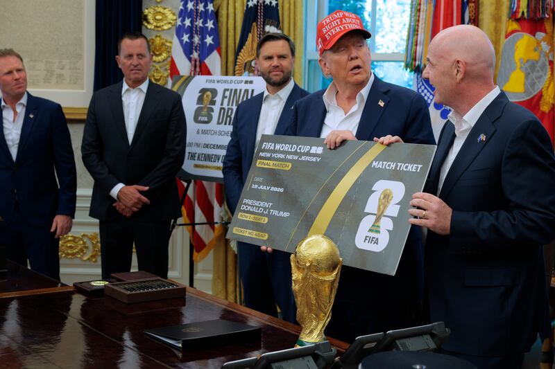 President Donald Trump is presented a novelty ticket by FIFA President Gianni Infantino during an announcement about the 2026 World Cup with Vice President JD Vance and Special Envoy Richard Grenell and White House FIFA 2026 Task Force Executive Director Andrew Giuliani in the Oval Office at the White House on August 22, 2025 in Washington, DC.
