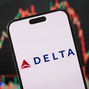 CHONGQING, CHINA - APRIL 6: In this photo illustration, the Delta Air Lines logo is displayed on a smartphone screen, with the company's stock market performance and candlestick charts visible in the background, showcasing Delta Air Lines' real-time financial trends, stock price movements, market fluctuations, and developments in the aviation and travel sectors, on April 6, 2025, in Chongqing, China. The current earnings season is showing weaker results compared to previous quarters, with fewer companies exceeding expectations across markets, and valuations in the tech sector coming under increasing scrutiny and uncertainly over tariffs taking a toll on both the S&P 500 and NASDAQ indices. (Photo by Cheng Xin/Getty Images)