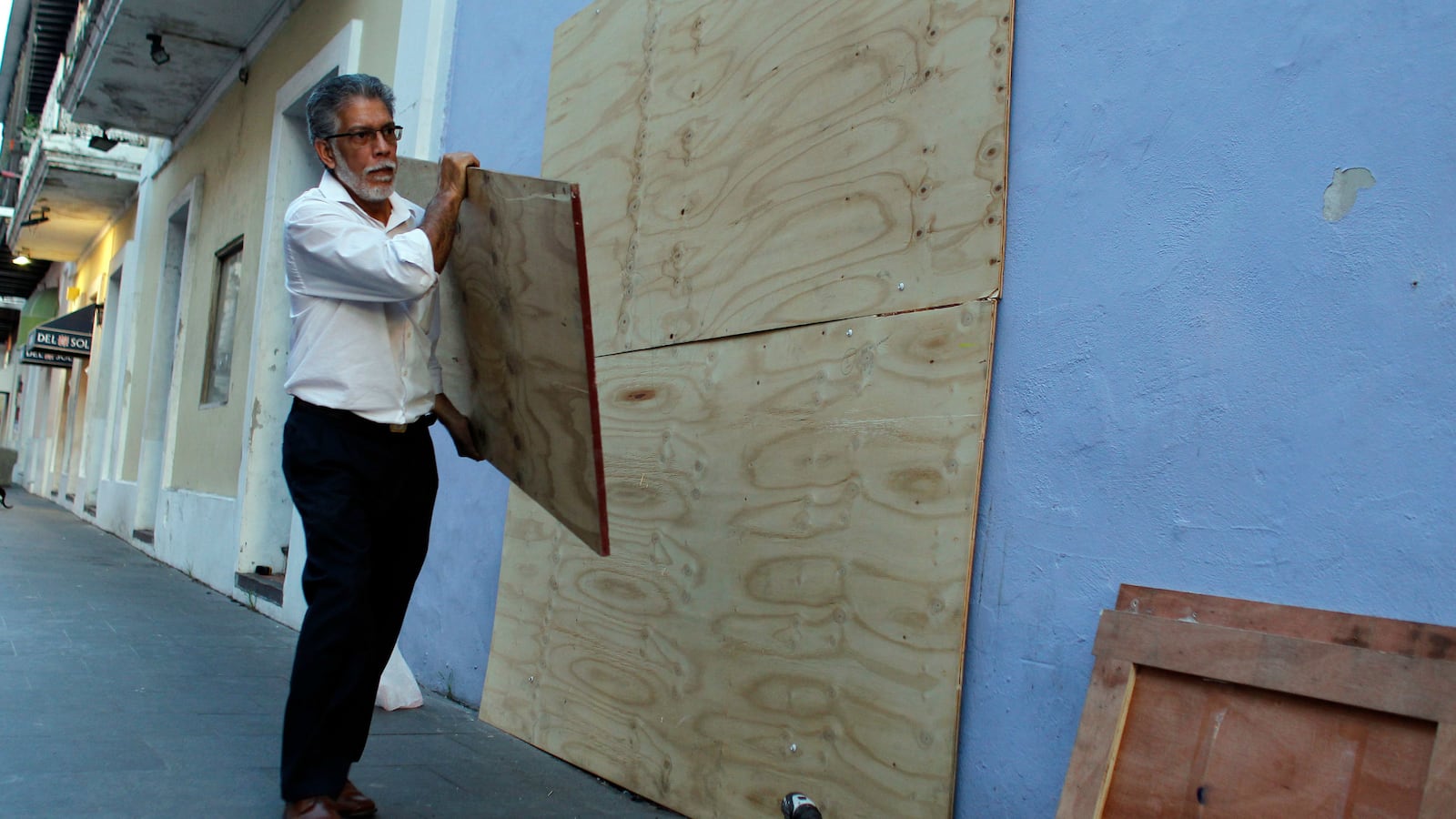 A man boards up windows of a business in preparation for Hurricane Maria in San Juan, Puerto Rico