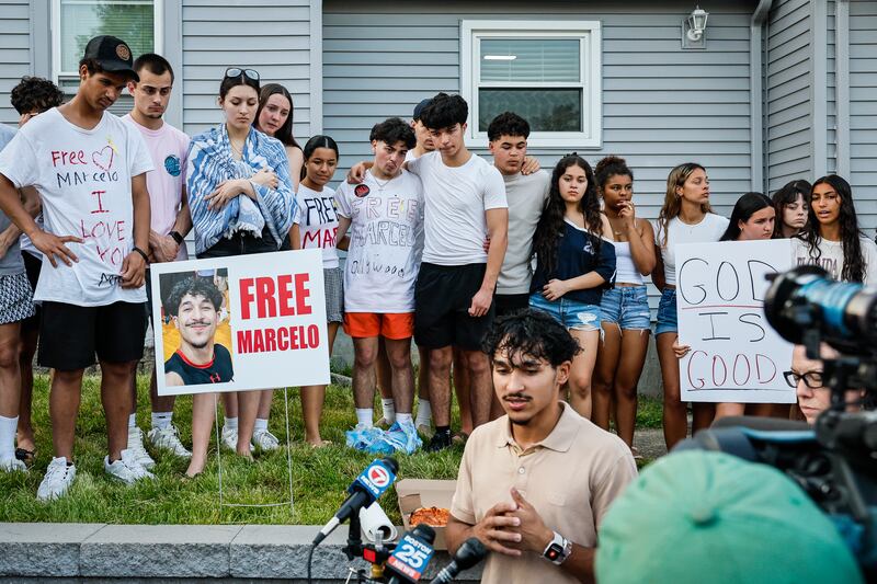 Milford, MA - June 5: Marcelo Gomes da Silva speaks to reporters outside his home on June 5, 2025, as friends holding "Free Marcelo" signs stand behind him after his release from ICE detention.