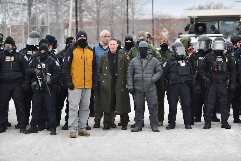 US Customs and Border Protection Commander Gregory Bovino (C) stands flanked by fellow federal agents during a protest against ICE outside the Bishop Whipple Federal Building in Minneapolis, Minnesota, on January 15, 2026. Hundreds more federal agents were heading to Minneapolis, the US homeland security chief said on January 11, brushing aside demands by the Midwestern city's Democratic leaders to leave after an immigration officer fatally shot a woman protester. In multiple TV interviews, US Homeland Secretary Kristi Noem defended the actions of the officer who shot and killed 37-year-old Renee Nicole Good, whose death has sparked renewed protests nationwide against President Donald Trump's immigration crackdown. (Photo by Octavio JONES / AFP via Getty Images)