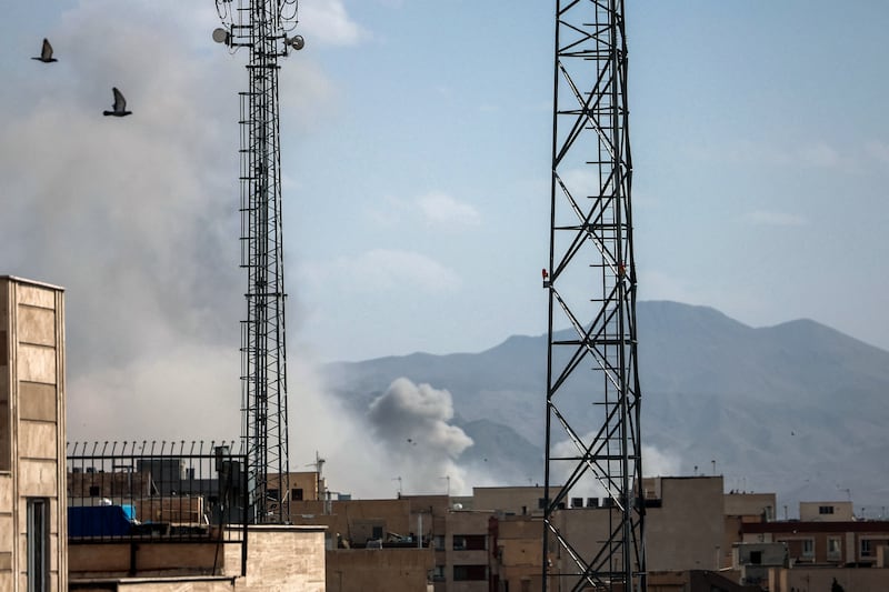 A plume of smoke rises following a reported explosion in Tehran on February 28, 2026. Iran said on February 28 it will "respond decisively" after Israel and the United States launched strikes on the country despite talks underway on Tehran's nuclear programme. (Photo by AFP via Getty Images)