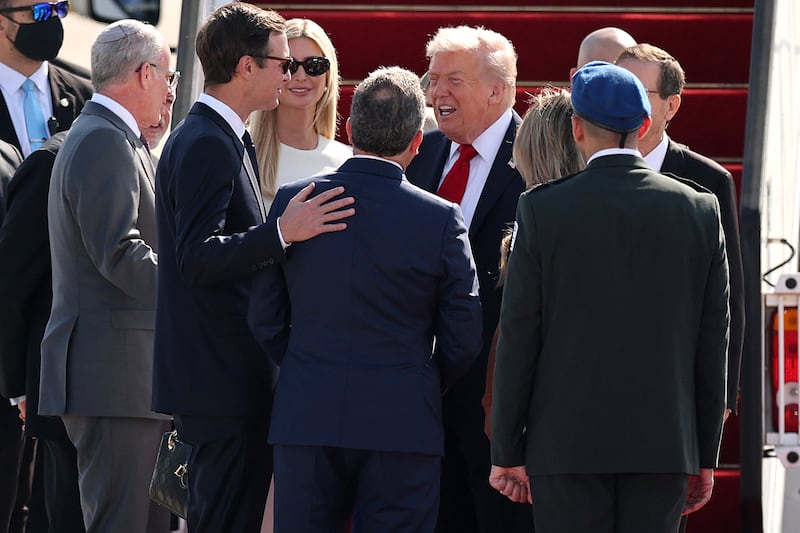 US President Donald Trump (C) is surrounded by his daughter Ivanka Trump (back C) and his son-in-law Jared Kushner (2ndL) along with Israeli officials upon his arrival at Ben Gurion Airport on the outskirts of Lod near Tel Aviv on October 13, 2025. Trump is passing through Israel, addressing parliament and meeting with hostage families before heading to Egypt's Sharm El-Sheikh for the summit, where a "document ending the war in the Gaza Strip" is expected to be signed. (Photo by Jack GUEZ / AFP) (Photo by JACK GUEZ/AFP via Getty Images)