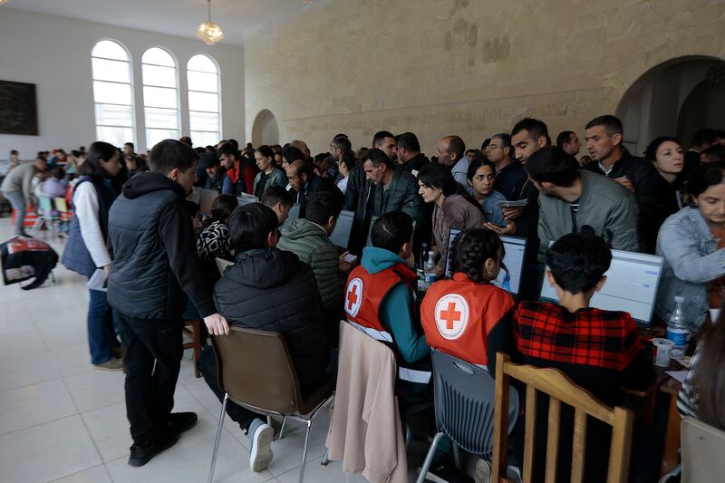 Red Cross workers help refugees at Goris theater.