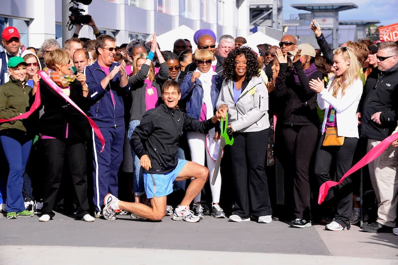 Media personality and physician Dr. Mehmet Oz (left center) and media personality Oprah Winfrey (right center) cut the ribbon to signal the start of the "Live Your Best Life Walk" to celebrate O, The Oprah Magazine's 10th Anniversary at Intrepid Welcome Center on May 9, 2010 in New York City.