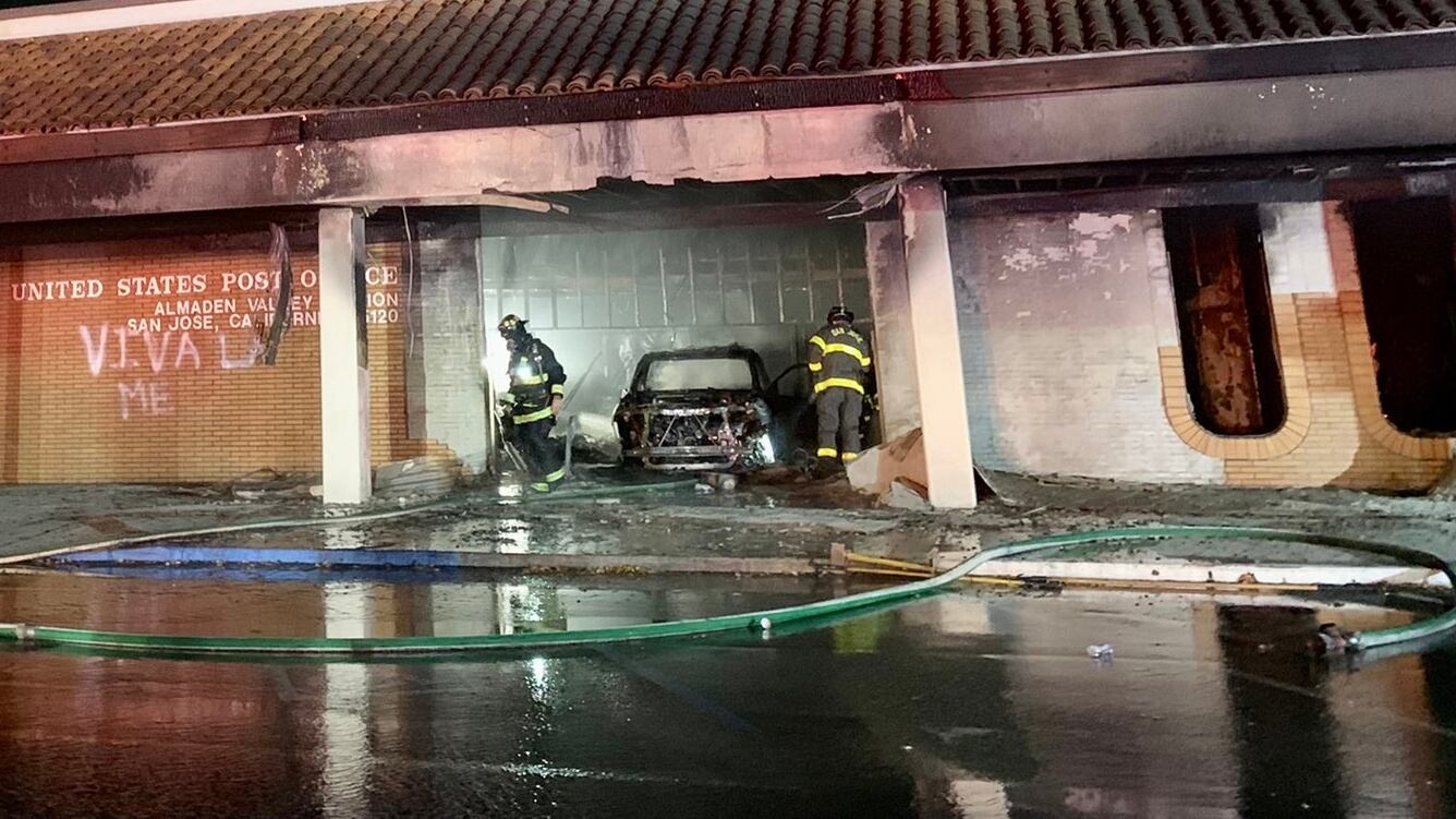San Jose firefighters respond to a burning vehicle that crashed into the Almaden Valley Station Post Office.