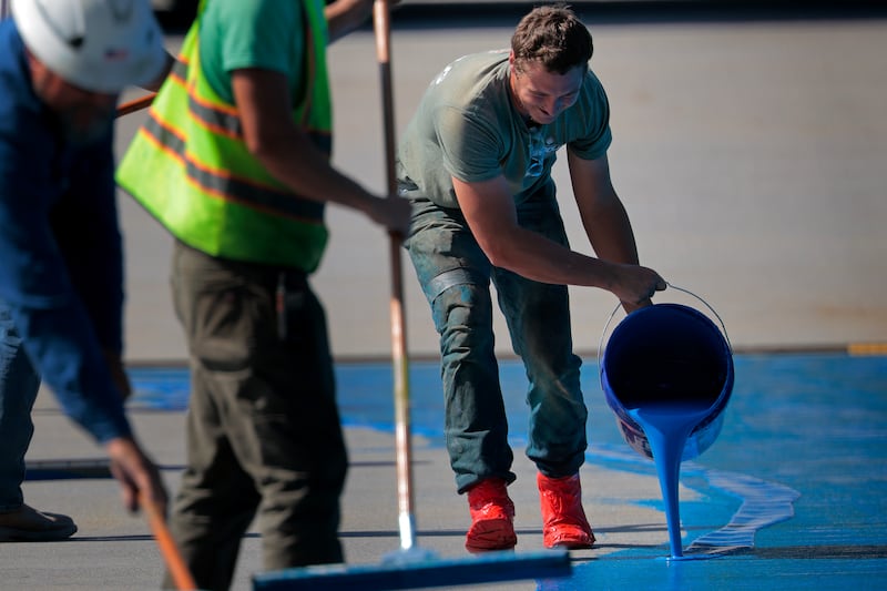 Workers spread a blue sealant onto the bottom of the Lincoln Memorial Reflecting Pool on the National Mall on May 28, 2026 in Washington, DC. Painting the landmark is part of President Donald Trump's effort to repair Washington landmarks in for preparation the country’s 250th birthday this summer.