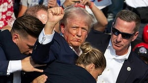 TOPSHOT - Republican candidate Donald Trump is seen with blood on his face surrounded by secret service agents as he is taken off the stage at a campaign event at Butler Farm Show Inc. in Butler, Pennsylvania, July 13, 2024. Donald Trump was hit in the ear in an apparent assassination attempt by a gunman at a campaign rally on Saturday, in a chaotic and shocking incident that will fuel fears of instability ahead of the 2024 US presidential election.
The 78-year-old former president was rushed off stage with blood smeared across his face after the shooting in Butler, Pennsylvania, while the gunman and a bystander were killed and two spectators critically injured. (Photo by Rebecca DROKE / AFP) (Photo by REBECCA DROKE/AFP via Getty Images)