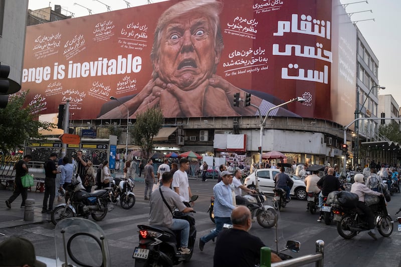 Motorcyclists and pedestrians move along an avenue beneath an anti-U.S. billboard depicting U.S. President Donald Trump in downtown Tehran, Iran, on August 23, 2026. The 60-day ceasefire between Iran and the United States ended on August 17, with no new agreement reached between the two sides. (Photo by Morteza Nikoubazl/NurPhoto via Getty Images)