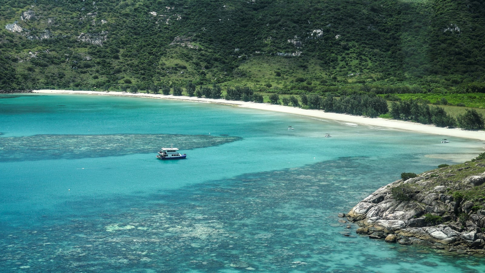 This aerial photo taken on April 4, 2024, shows a boat anchored near coral around Lizard Island on the Great Barrier Reef, located 270 kilometres (167 miles) north of the city of Cairns. Australia's famed Great Barrier Reef is teetering on the brink, suffering one of the most severe coral bleaching events on record -- the fifth in eight years -- and leaving scientists unsure about its survival.
