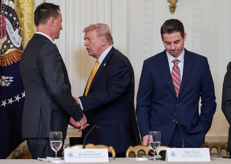 Outgoing President of the Kennedy Center Richard Grenell greets U.S. President Donald Trump, with Vice President of operation at the Kennedy Center Matt Floca, who is set to become the new President of the Kennedy Center, next to them, at a lunch with the Kennedy Center board members in the East Room of the White House in Washington, D.C., U.S., March 16, 2026. REUTERS/Jonathan Ernst