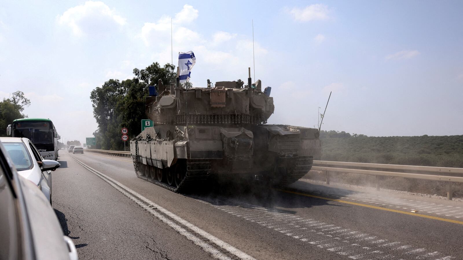 An Israeli tank drives on a road following a mass infiltration by Hamas gunmen from the Gaza Strip