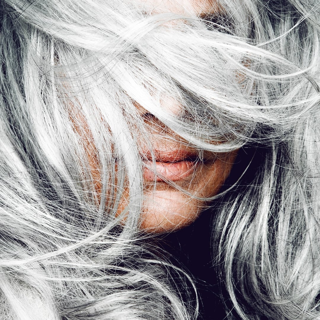 Woman tossing her silver hair.