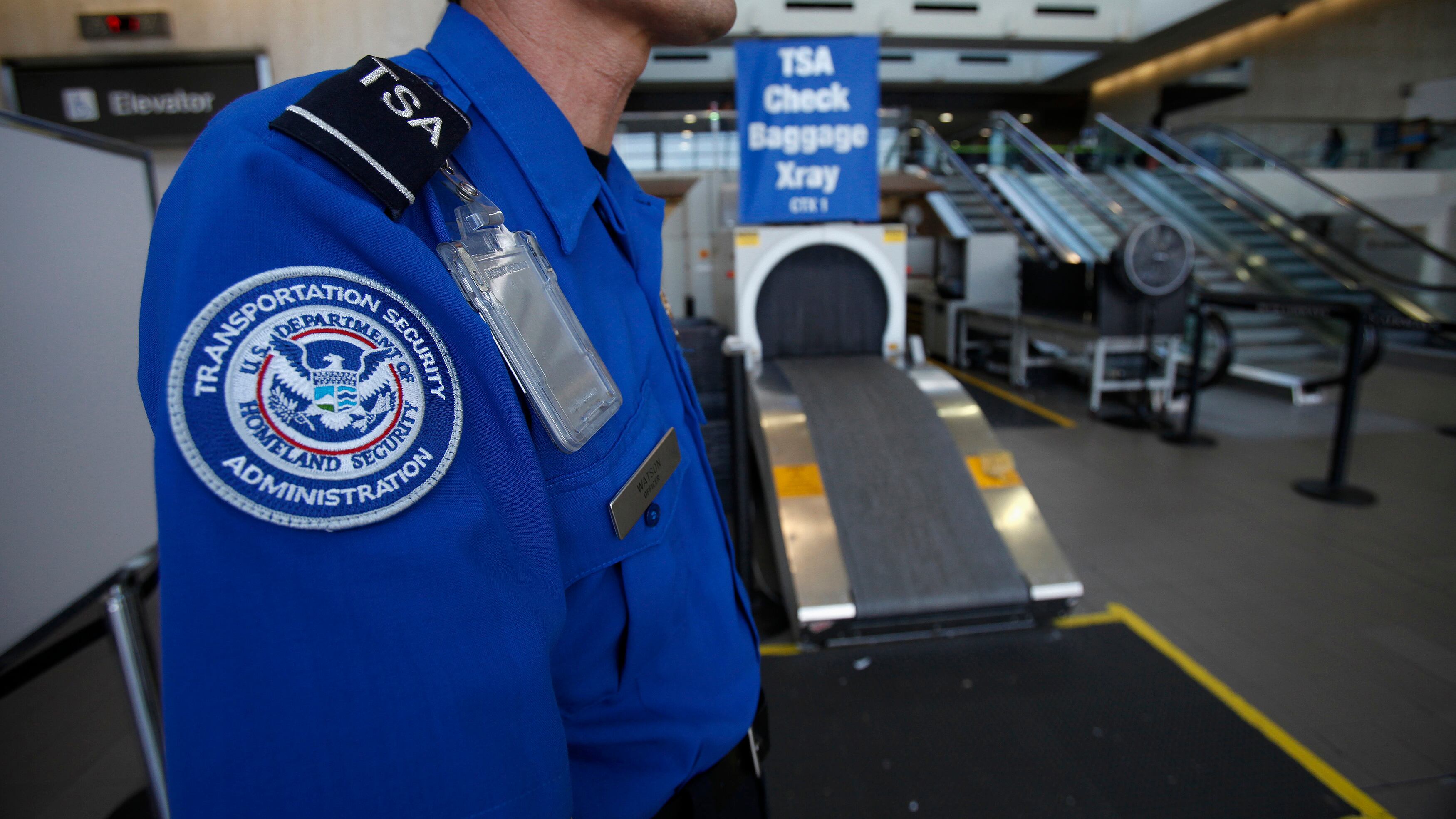 TSA agent at airport screening checkpoint.