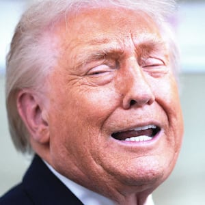 U.S. President Donald Trump speaks to reporters on board Air Force One