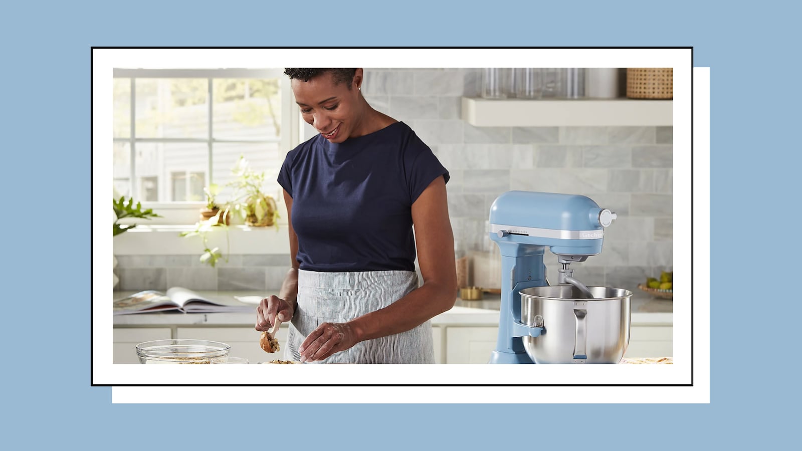 Woman in kitchen with a blue KitchenAid 7 Quart Bowl-Lift Stand Mixer next to her