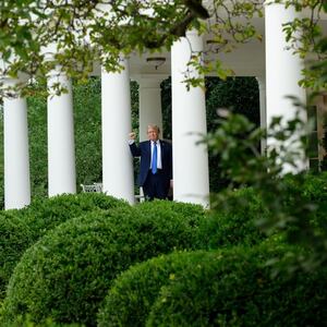 President Donald Trump tests the speakers of the newly renovated Rose Garden.