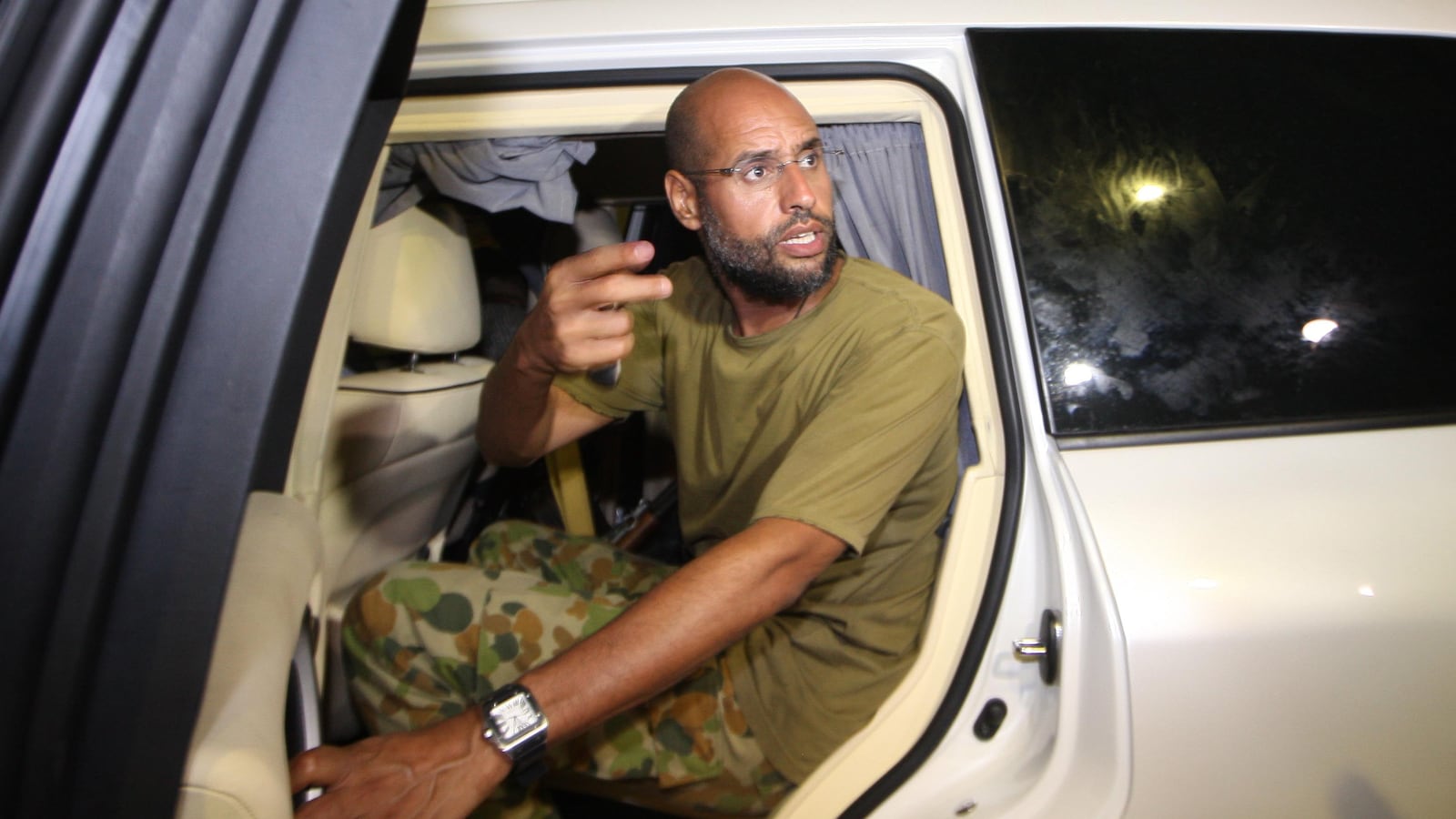 Saif al-Islam Kadhafi, son of Libyan leader Moamer Kadhafi, appears in front of supporters and journalists at his father's residential complex in the Libyan capital Tripoli in the early hours of August 23, 2011. Seif al-Islam, wanted by the International Criminal Court for crimes against humanity and who ICC prosecutor Luis Moreno-Ocampo earlier said had been arrested by the rebels, claimed the insurgents had suffered "heavy casualties" when they stormed Kadhafi's Bab al-Azizya compound in Tripoli. AFP PHOTO/IMED LAMLOUM (Photo credit should read IMED LAMLOUM/AFP via Getty Images)