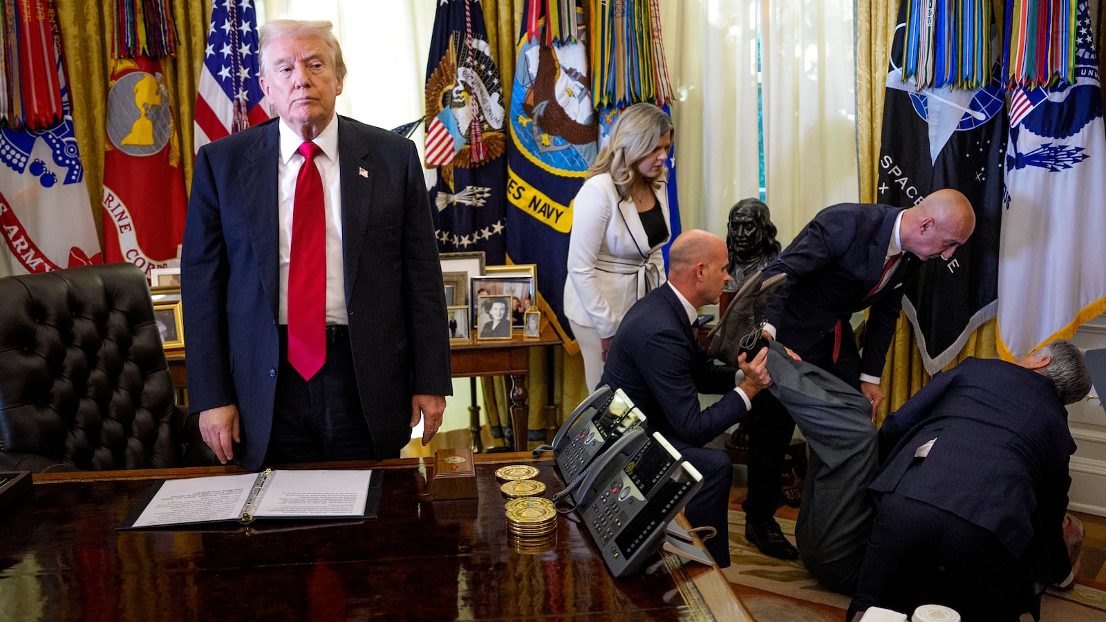 WASHINGTON, DC - NOVEMBER 06: (EDITOR'S NOTE: Alternate Crop) U.S. President Donald Trump stands by as attendees help a guest after he collapsed during during an event on lowering drug prices in the Oval Office at the White House on November 06, 2025 in Washington, DC. Trump announced that his administration has reached agreements with drugmakers Eli Lilly and Novo Nordisk that would lower the price of some GLP-1 weight loss medications. (Photo by Andrew Harnik/Getty Images)