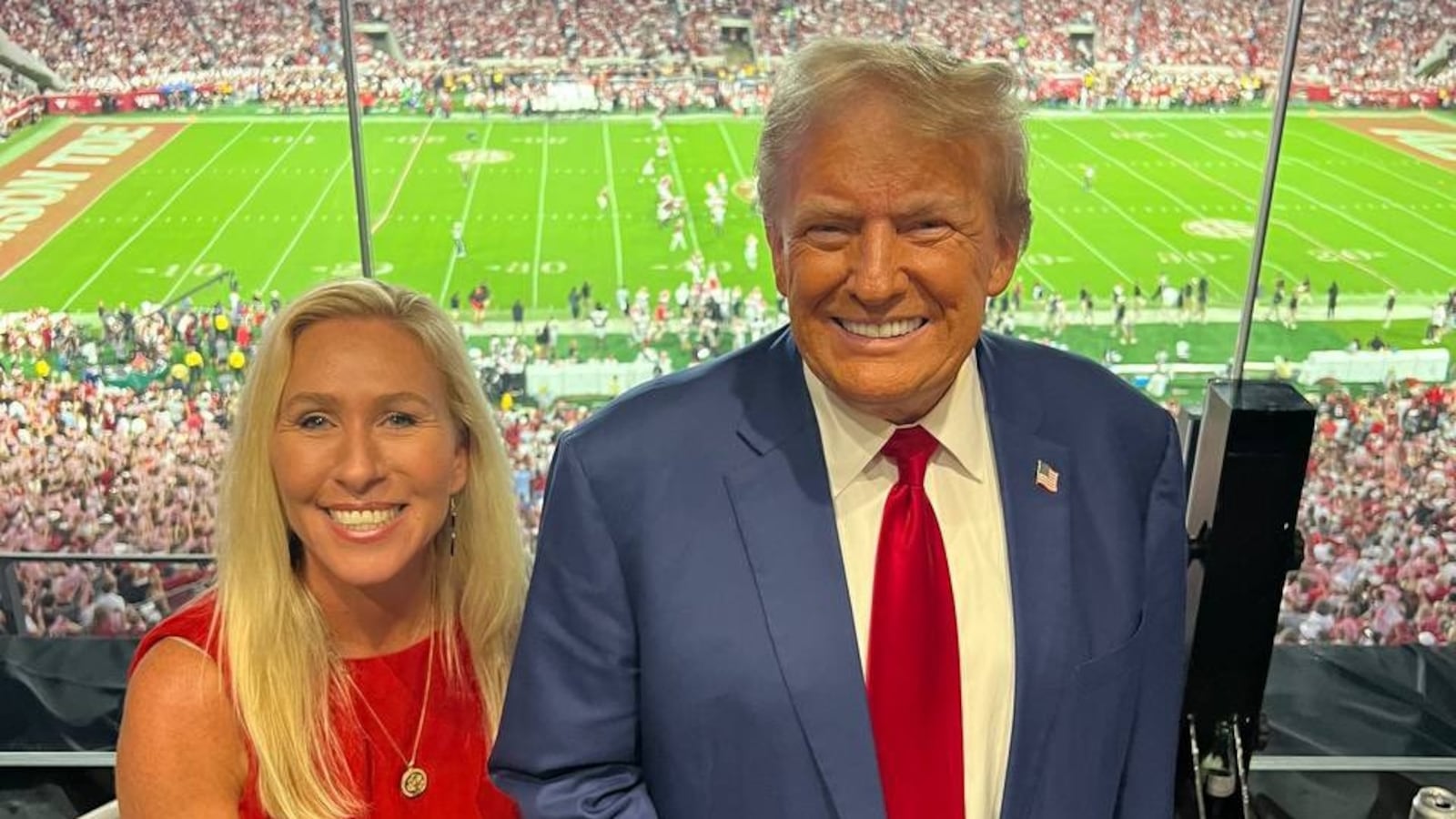 Marjorie Taylor Greene and Donald Trump pose together at an Alabama football game.