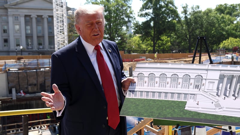 U..S. President Donald Trump shows images of the concept at the site of ongoing construction of the planned White House ballroom in Washington, D.C., U.S., May 19, 2026.