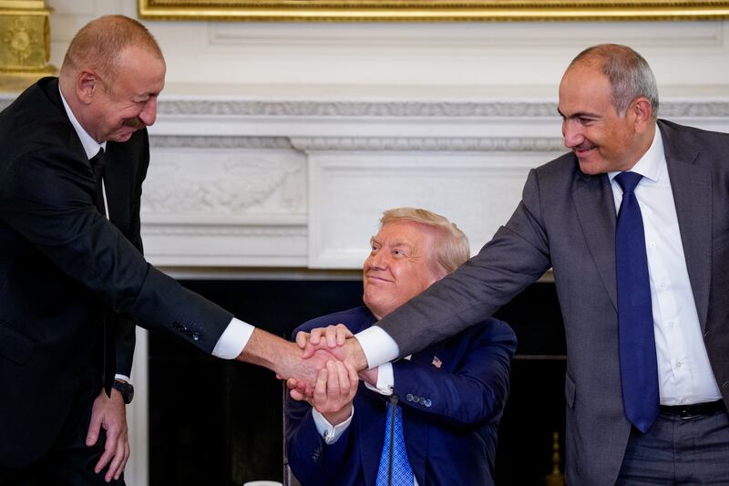 President Donald Trump (C) joins hands with Azerbaijani President Ilham Aliyev (L) and Armenian Prime Minister Nikol Pashinyan (R) during a signing ceremony in the State Dining Room of the White House on August 8, 2025 in Washington, DC. Trump brought the two leaders together in an initial attempt to end the conflict between Armenia and Azerbaijan that has lasted for decades. (Photo by Andrew Harnik/Getty Images)