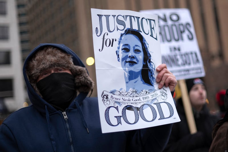 A demonstrator holds a sign with a photo of Renee Nicole Good