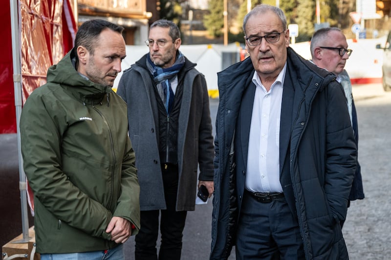 Swiss President Guy Parmelin (R) and Head of the Department of Social Affairs and Culture of the Canton of Valais Mathias Reynard (L) visit the area where a fire ripped through the bar Le Constellation during New Year's Eve celebrations in Crans-Montana, on January 1, 2026. Several dozen people are presumed dead and around 100 injured after a fire ripped through a crowded bar in the luxury Swiss ski resort of Crans-Montana, Swiss police said on January 1, 2026. Police, firefighters and rescuers rushed to the popular resort, which is set to host the Ski World Cup from January 30, after the fire broke out in the early hours of New Year's Day. (Photo by ALESSANDRO DELLA VALLE / POOL / AFP via Getty Images)