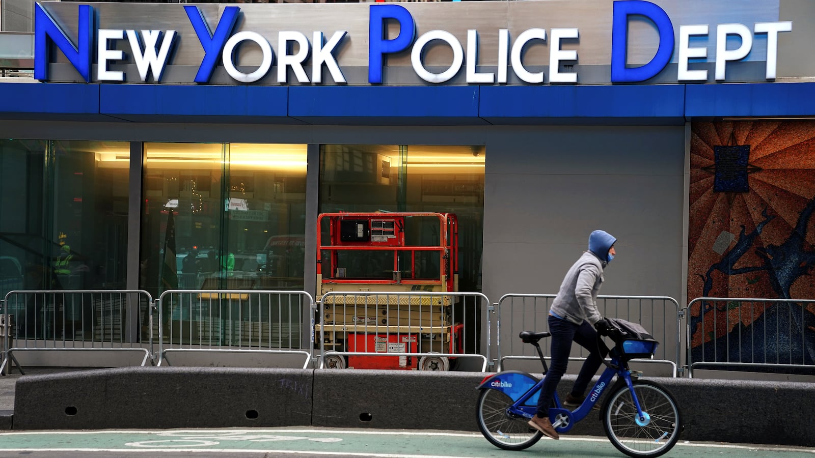 A bicyclist rides past a New York Police Department precinct.