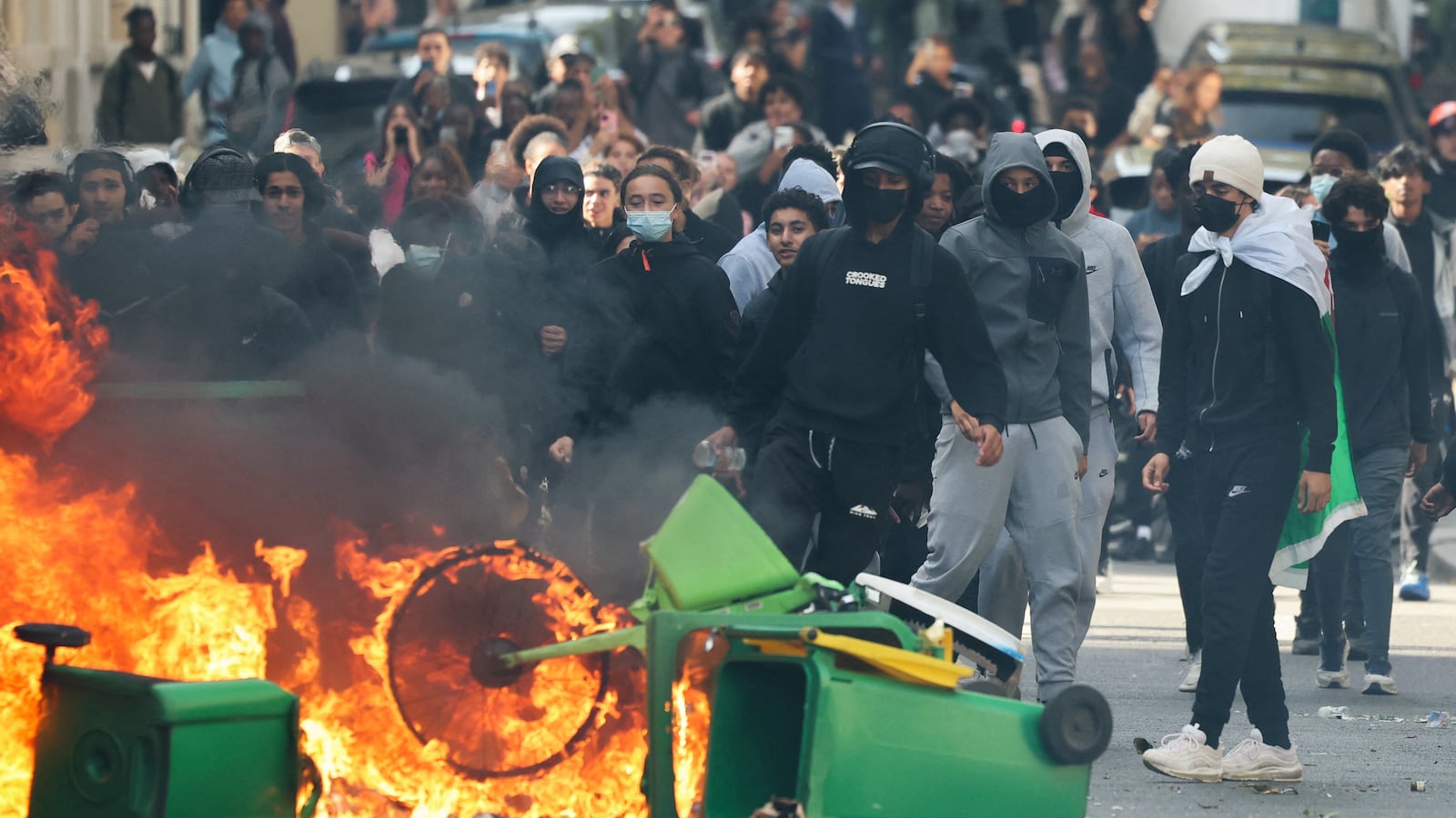 TOPSHOT - A student puts trashes into a fire as protesting students carry out blockading action near place de la Nation, in Paris, on October 2, 2026. Since late September, students have staged protests outside schools over grievances ranging from timetables, class sizes and a shortage of teachers to overheated classrooms during this year's heatwaves. The protests started in the Ile-de-France region around Paris but have now spread to other cities nationwide. (Photo by Thomas SAMSON / AFP via Getty Images